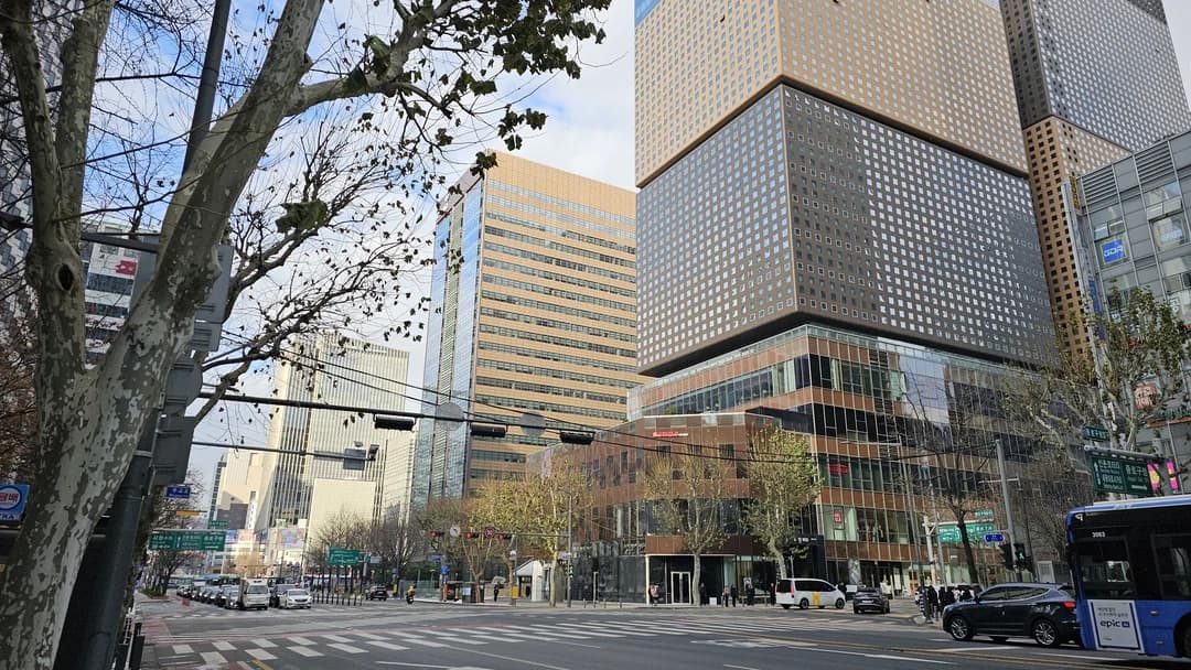 A wide city street in central Seoul lined with office towers and bare winter trees